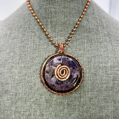 Necklace with a purple stone pendant on a gray fabric background