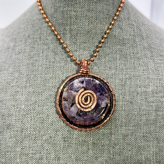 Necklace with a purple stone pendant on a gray fabric background