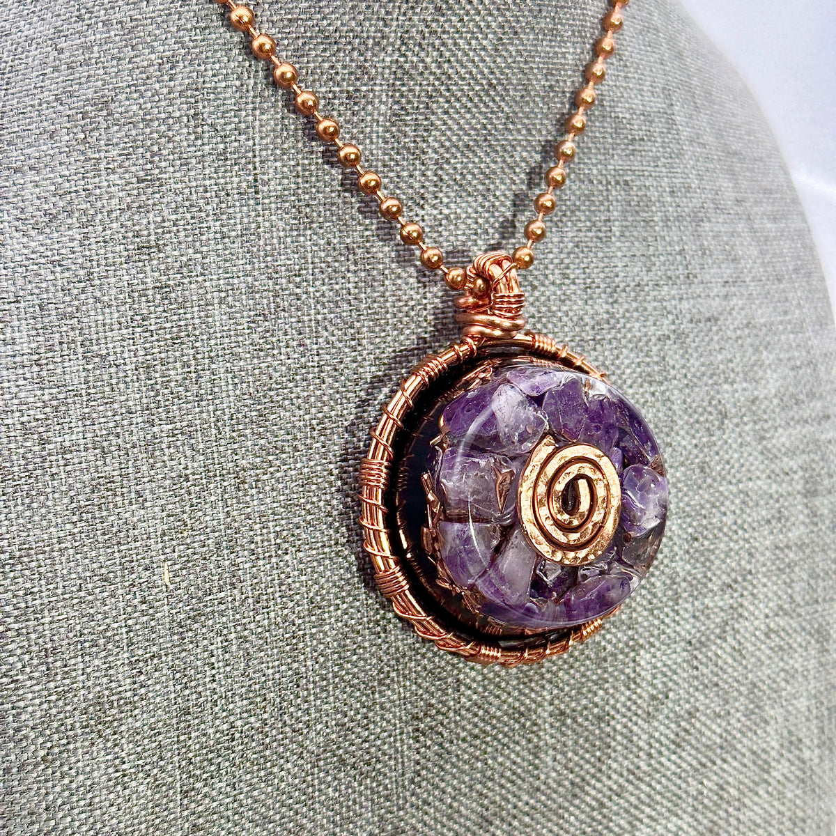 Necklace with a purple gemstone pendant on a textured surface